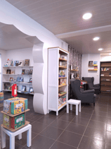 Photo de la transformation avec vue sur un coin lecture et un mur découpé en nuage