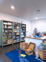 Magasin de jouets avec étagères vert sauge et plan de travail 
