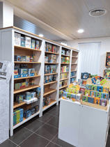 Aménagement du magasin de jouets avec des étagères blanches et un plan de travail comme présentoir