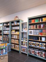 Transformation d'un magasin de jouets avec vue sur des étagères vert sauge