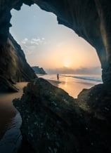 a person standing on a rock formation in the ocean .  arbab naimat kasi , balochistan , sapat