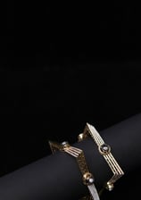 a pair of gold toned bracelets with a black and white bracelet portraitsbykaiff