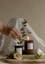 a person holding a candle in front of a wooden board