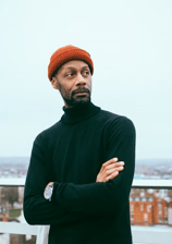 a man in a black sweater and a red hat