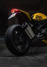 a motorcycle parked in a garage with a yellow and black motorcycle