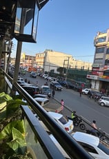 a view of a city street with cars parked on the side of the street