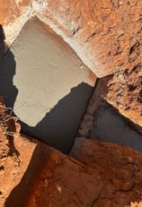 a person standing on a rock face with a shadow on the ground