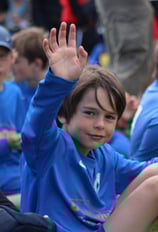 enfant de face levant la main