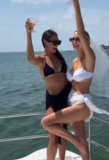 two women standing on a boat in the ocean