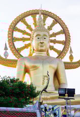 A close-up of the iconic Big Buddha statue on Koh Samui, Thailand. The golden Buddha