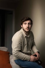 a man sitting on a couch with a remote control