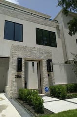 A beige brick and stucco two story home sparkling and spotless after a good window cleaning