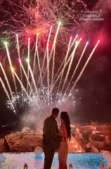 Vibrant fireworks display synchronized with music at a Santorini wedding party.