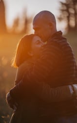 uomo-e-donna-che-si-baciano-al-tramonto