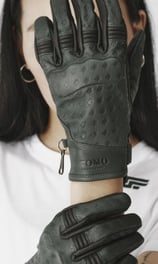 a woman wearing a white shirt and black gloves