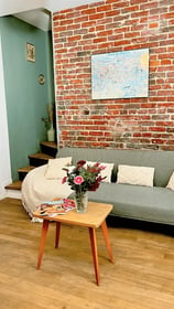 Relaxation area of the Maison des Voyageurs, featuring an industrial style with exposed brick walls 