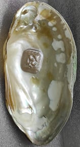 "Side view of 11mm white designer cultured pearl with detailed Om engraving–Globally tradable"