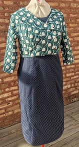 The front of a navy polka dot reversible sheath dress and green 50's inspired jacket