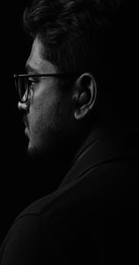 a man in glasses and a black shirt