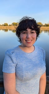 A picture of Rae O'Connor standing in front of a pond