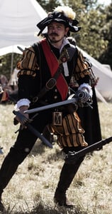 Homme en tenue jaune et noire lansquenaise en bataille. Il a une belle moustache