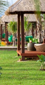 a woman sitting on a bench in a tropical setting