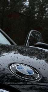 bmw logotipas ant automobilio gaubto, demonstruojantis hidrofobinį paviršių