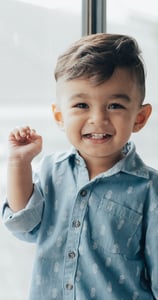 Smiling young boy in front of a window