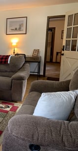 Cozy living room with a two reclining couches, coffee table and a Roku Smart TV. 