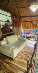 Cozy room with a comfortable sofa on the porch, perfect for relaxing in a rustic bamboo hut.