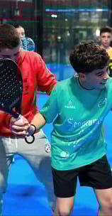 Padel coach demonstrating shot technique during group training session near Barcelona