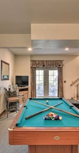 Cozy game room at Moose Creek Lodge featuring a pool table, TV, and lounge area with deck access.