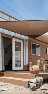 Tiny home pod with deck, shade sail, and outdoor seating