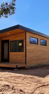 Modern tiny home pod with wood siding and black trim