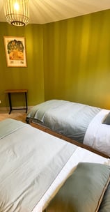 a bedroom with two beds and a lamp