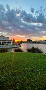 a sunset over a lake with a boat in the foreground, Zuytland-Buiten Simonshaven, Zuid-Holland