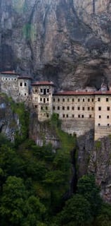 a mountaintopping with a large building in the background