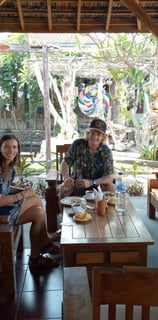 a man and woman sitting at a table with drinks enjoying the momemt at sunrise lodge & lounge