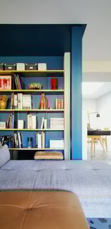 Bibliothèque sur mesure en bois clair et métal brut verni. Ouverture sur bureau lumineux avec Vélux