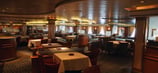 Restaurante elegante a bordo de navio de cruzeiro, com mesas arrumadas.