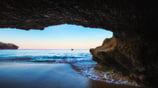 a person standing in front of a cave in a cave