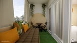 Balcon aménagé avec une assise en palette teintes colorées, style exotique et un espace repas