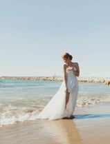 Novia en su vestido, caminando en la playa