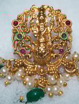 a gold broocher with pearls and pearls