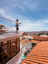 a woman standing on a balcony with a view of the city