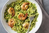 a bowl of pasta with shrimp and pesto sauce