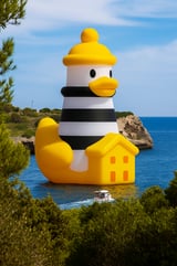 a giant yellow rubber duck in the water of Portocolom