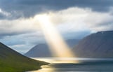 sunbeam coming through clouds onto water
