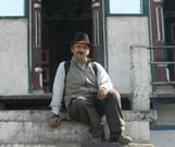 a man sitting on a ledge in front of a building