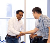 a man shaking hands with another man in a room
